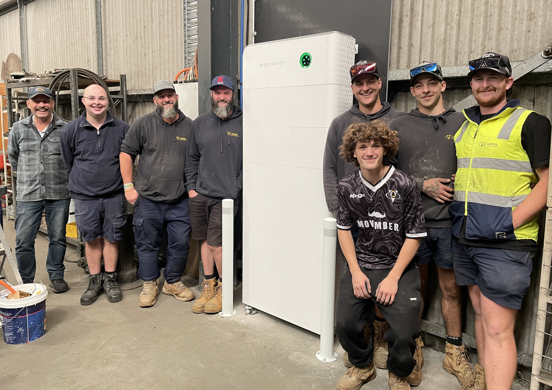 Project participants standing beside the Sigenergy battery at Lakers Siding
